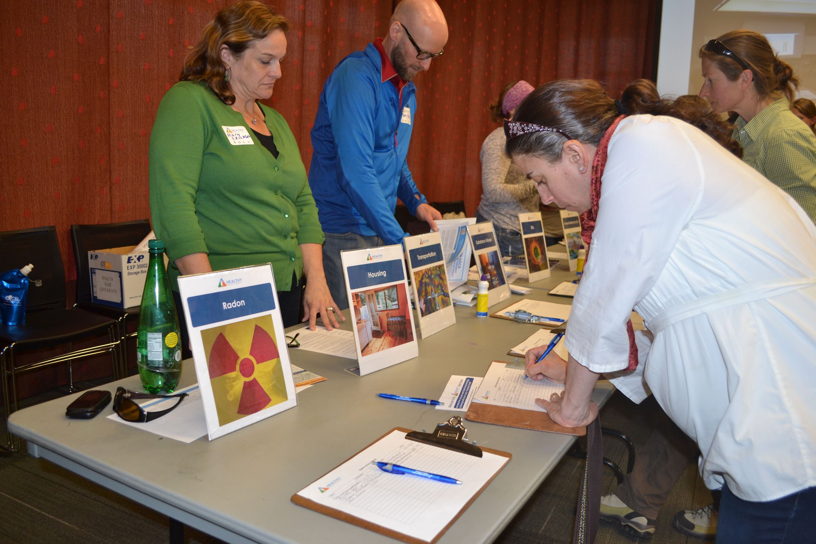 image of a woman writing on a piece of paper at a booth